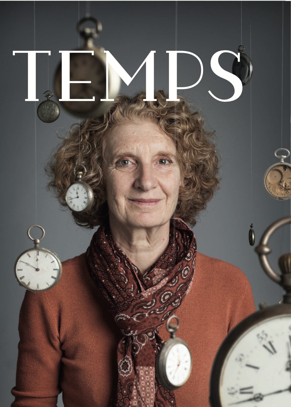 Couverture du magazine Temps : une femme aux cheveux bouclés, en pull orange, entourée de montres à gousset suspendues.